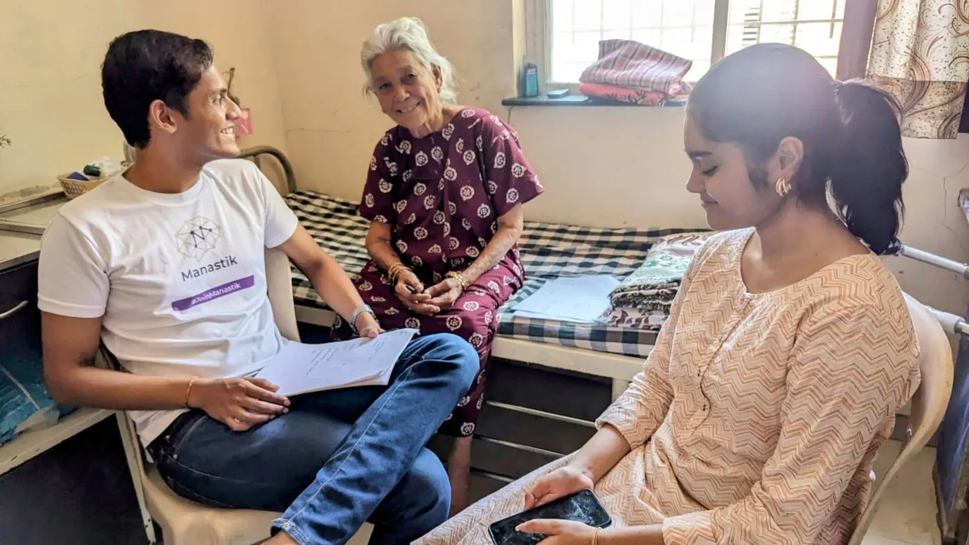 Manastik team members talking with an elderly woman at a dementia awareness camp